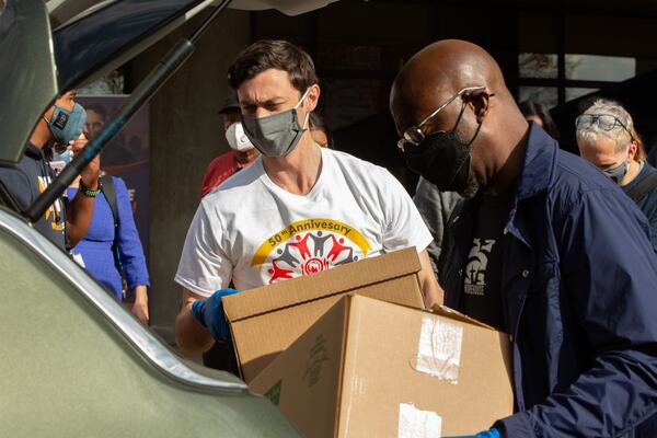 Jon Ossoff (left) and the Rev. Raphael Warnock, Democratic candidates for the two U.S. Senate seats facing January runoffs in Georgia, help to load food into cars during the annual Hosea Williams Thanksgiving Dinner outside the Georgia World Congress Center on Thursday, November 26, 2020. (Photo: Steve Schaefer for The Atlanta Journal-Constitution)