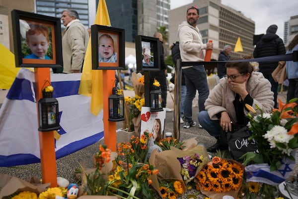 A woman mourns in a memorial for deceased hostages Shiri Bibas, her two children, Ariel and Kfir, and Oded Lifshitz on Saturday.