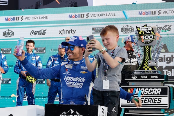 Kyle Larson, front left, celebrates with his son Owen, front right, in Victory Lane after winning a NASCAR Cup Series auto race at Homestead-Miami Speedway in Homestead, Fla., Sunday, March 23, 2025. (AP Photo/Terry Renna)