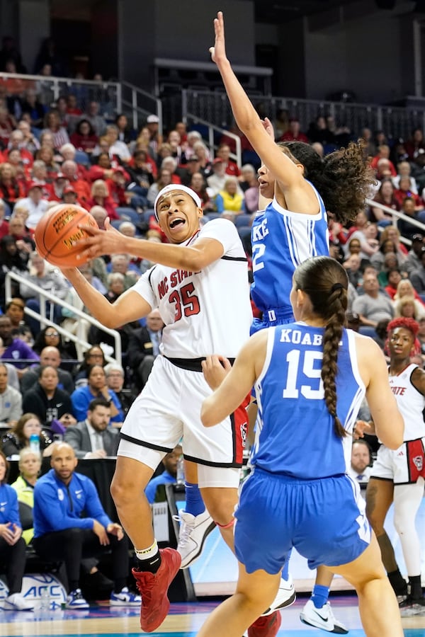 NC State guard Zoe Brooks (35) shoots as Duke guard Emma Koabel (15) and Duke forward Delaney Thomas (12) defend during an NCAA college basketball game in the championship of the Atlantic Coast Conference tournament Greensboro, N.C., Sunday, March 9, 2025. (AP Photo/Chuck Burton)