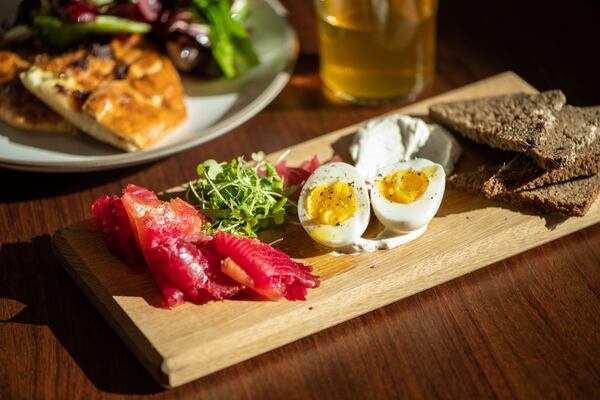 Le Bon Nosh beet-cured salmon with tzatziki, soft-boiled eggs, pickled red onion, herb salad, and rye bread. (Mia Yakel for The Atlanta Journal-Constitution)