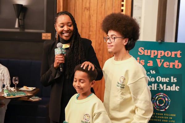 Lakeysha Hallmon (from left) appears with nephews Amir Poindexter, 9, and Sean Poindexter, 16, at her book launch party for “No One is Self-Made” at The Gathering Spot in Atlanta on Friday, Feb. 7, 2025. (Arvin Temkar/AJC)