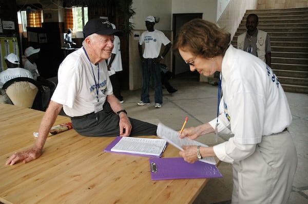 Jimmy and Rosalynn Carter prepare for poll closing procedures during elections in Monrovia, Liberia, in 2005. In the last 35 years, the couple have observed dozens of elections. (The Carter Center)