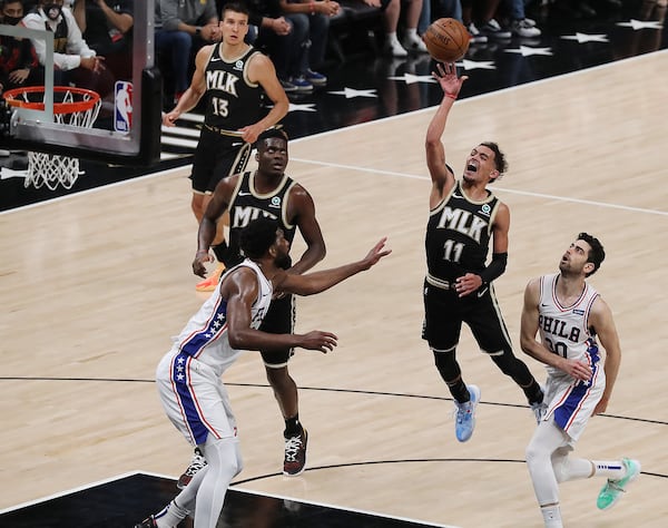 Hawks guard Trae Young puts up a floater over Philadelphia 76ers center Joel Embiid.   “Curtis Compton / Curtis.Compton@ajc.com”