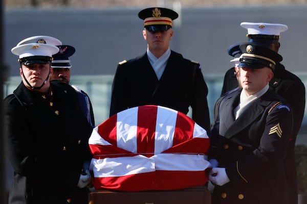 A military team carries the casket of President Jimmy Carter to his hearse during his departure ceremony from the Carter Presidential Center in Atlanta on Tuesday.