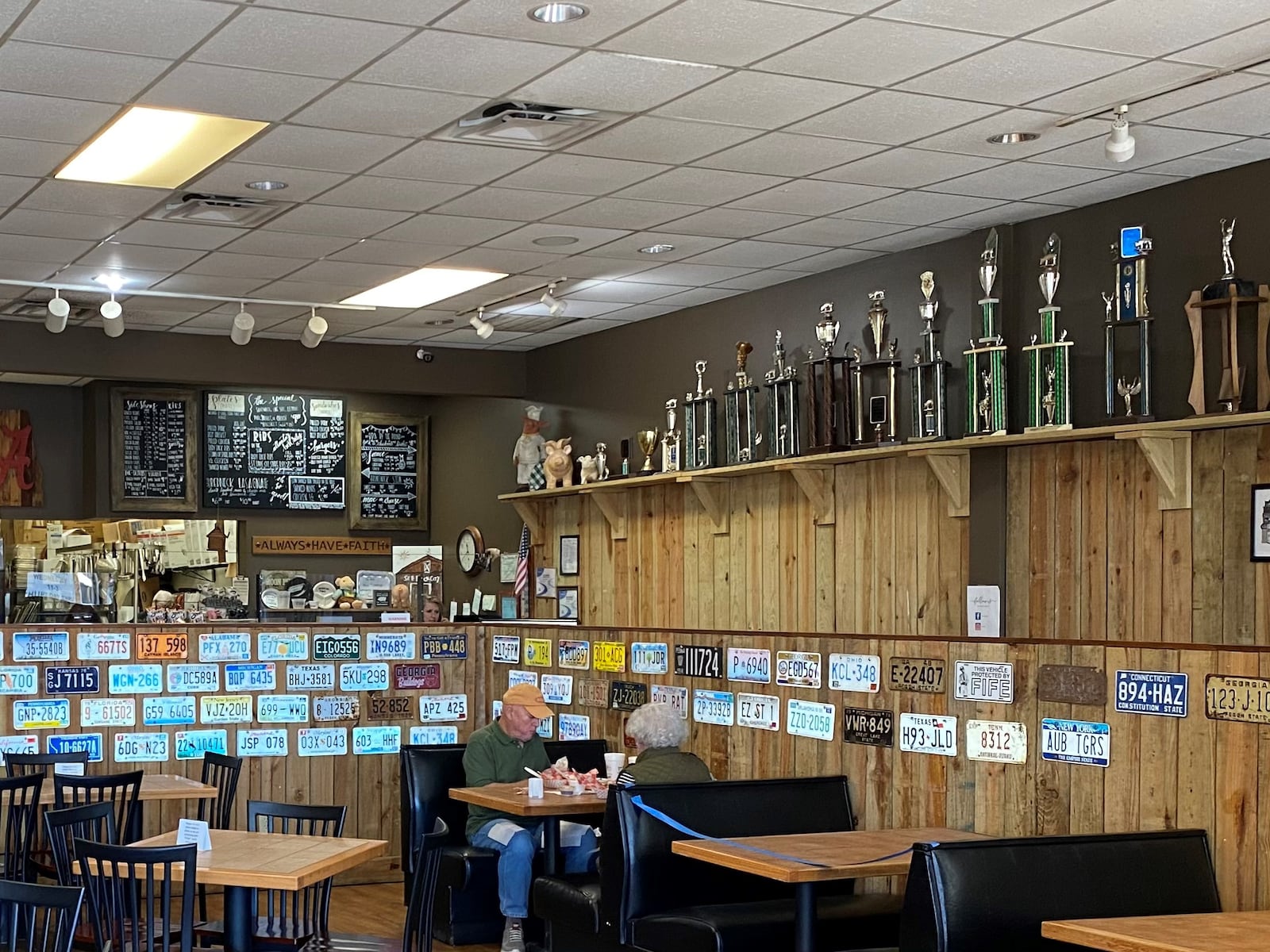 A shelf full of barbecue competition trophies greets visitors to Dave Poe’s BBQ in Marietta. Bob Townsend for The Atlanta Journal-Constitution 
