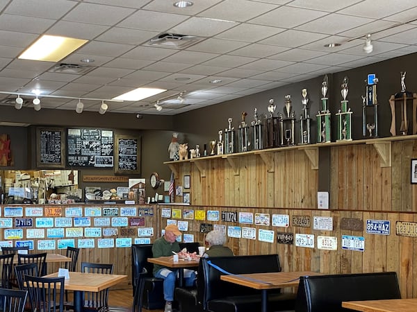 A shelf full of barbecue competition trophies greets visitors to Dave Poe’s BBQ in Marietta. Bob Townsend for The Atlanta Journal-Constitution 
