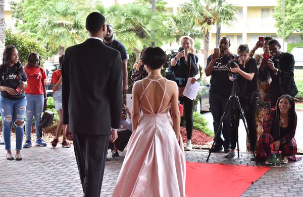 Stone Mountain High School seniors Chauncey Holt (foreground left) and Bawi Parr walk the red carpet before being chauffeured to their prom at the Twelve Hotel in Atlantic Station. HYOSUB SHIN / HSHIN@AJC.COM