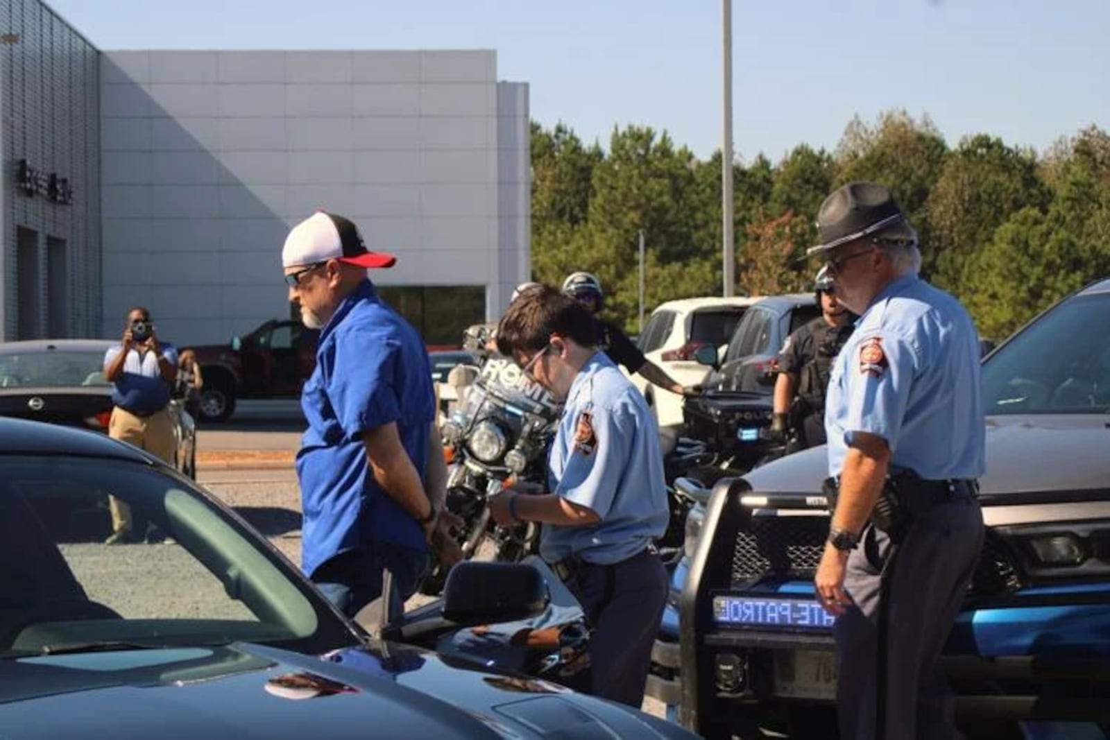 Grant Minton, under the supervision of a real Georgia state trooper, helps arrest the driver of the black sports car during a car-chase exercise Thursday afternoon. (Photo Courtesy of Adam Carey)