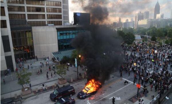 An Atlanta police car was set on fire outside the CNN Center during the first night of protests last month.