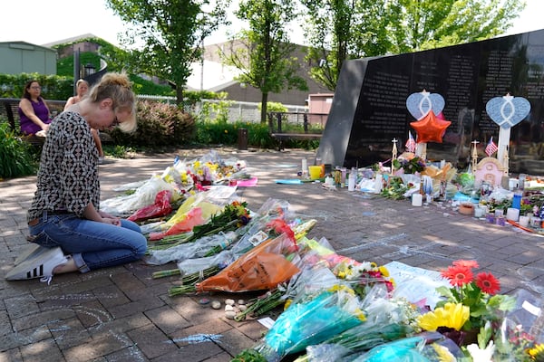 FILE - A visitor prays at a memorial to the seven people killed and others injured in the Fourth of July mass shooting at the Highland Park War Memorial in Highland Park, Ill., Thursday, July 7, 2022. (AP Photo/Nam Y. Huh, File)