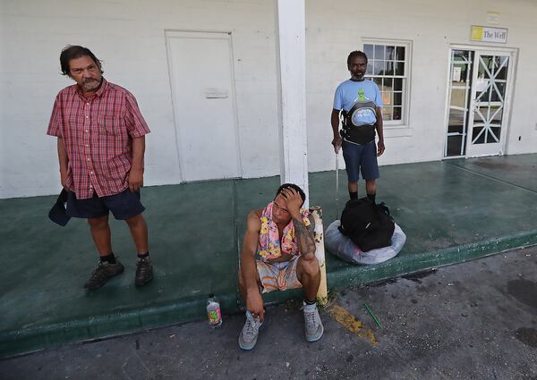  Homeless adults who declined to evacuate Brunswick wait Tuesday outside The Well run by Faith Works, which provides food for the area needy, only to find it closed with Hurricane Dorian approaching.   Curtis Compton/ccompton@ajc.com