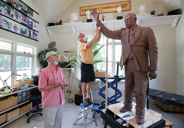 072820 Cumming: Sculptor Gregory Johnson (right) works on a one and one-third life-size statue of John Lewis made with 800 pounds of clay that will be cast in bronze at his studio while patron Rodney Mims Cook Jr. (left) checks on the progress on Tuesday, July 28, 2020 in Cumming.    Curtis Compton ccompton@ajc.com