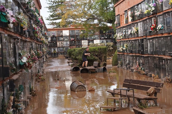 A man walks inside a flood damaged cemetery on the outskirts of Valencia, Spain, Friday, Nov. 1, 2024 after flooding in the region. (AP Photo/Alberto Saiz)