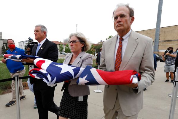 Speaker Philip Gunn, R-Clinton, left, Lt. Gov. Delbert Hosemann, right, and Mississippi Department of Archives and History Director Katherine Blount, center, carry the former Mississippi state flags to the Two Mississippi Museums during its retirement ceremony in Jackson, Miss., Wednesday, July 1, 2020. The flags had flown over the Capitol grounds during the day. The banner was the last state flag with the Confederate battle emblem on it. (AP Photo/Rogelio V. Solis)