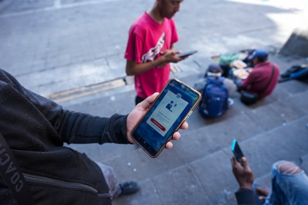 FILE - Venezuelan migrant Yender Romero shows the U.S. Customs and Border Protection (CBP) One app on his cell phone, which he said he used to apply for asylum in the U.S. and is waiting on an answer, at a migrant tent camp outside La Soledad church in Mexico City, Monday, Jan. 20, 2025, the inauguration day of U.S. President Donald Trump. (AP Photo/Fernando Llano, File)