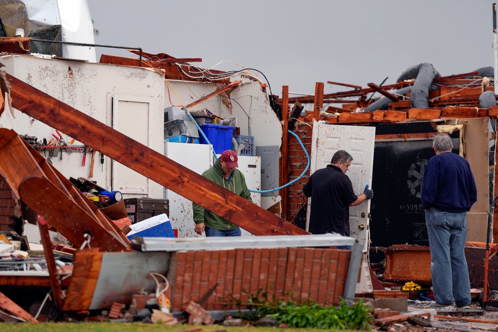 People inspect damage to a home along SE 84 after a tornado hit the area in Oklahoma City, Sunday, Nov. 3, 2024. (Bryan Terry/The Oklahoman via AP)