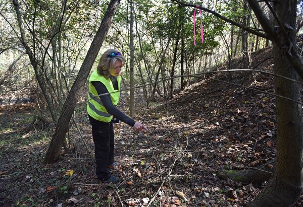 Private investigator Jane Holmes puts a marking tape where K-9 Chance found a piece of bone during their search for the body of DeCorrius Jones, who has been missing since October 15, 2016. HYOSUB SHIN / HSHIN@AJC.COM