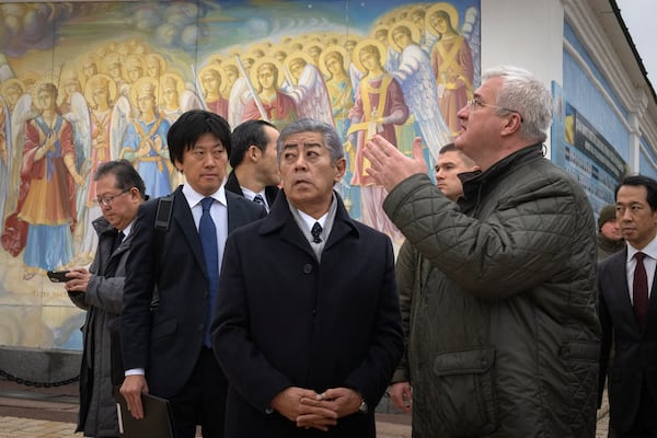 Japanese Foreign Minister Takeshi Iwaya, center, with Ukraine's Foreign Minister Andriiy Sybiha at the entrance of St. Michael Monastery in Kyiv, Ukraine, Saturday, Nov. 16, 2024. (AP Photo/Efrem Lukatsky)