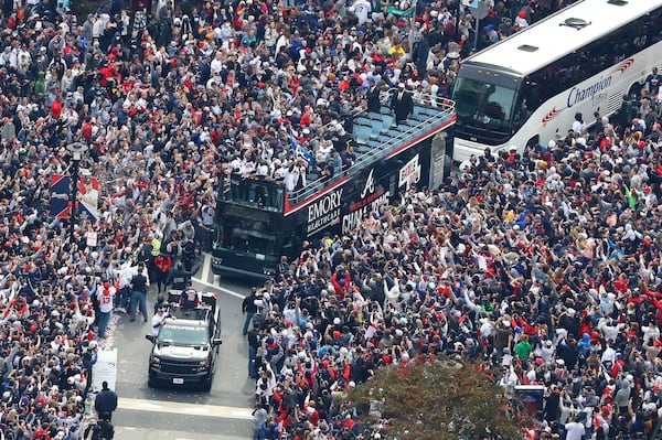 110521 ATLANTA: Braves players hoist the Commissioner's Trophy from the top of a double decker bus surrounded by thousands of fans as they arrive in the Battery outside Truist Park while the Atlanta Braves host a World Series Championship Parade and celebration on Friday, Nov. 5, 2021, in Atlanta.   “Curtis Compton / Curtis.Compton@ajc.com”