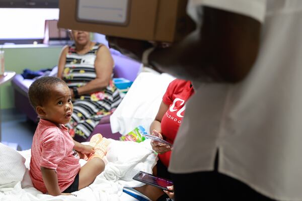 Grayson Simms, 3, looks up as NFL Hall of Famer and former Georgia Tech player Calvin Johnson walks into his room at Egleston Children’s Hospital in Atlanta on Friday, September 1, 2023. (Natrice Miller/ Natrice.miller@ajc.com) 