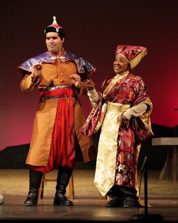 Cristian Gonzalez portrays General Mahzuno and Brenda Porter stars as Rhonda Charles in Topher Payne’s “Greetings Friend Your Kind Assistance Is Required,” a world premiere at Georgia Ensemble Theatre in Roswell. CONTRIBUTED BY DAN CARMODY / STUDIO 7