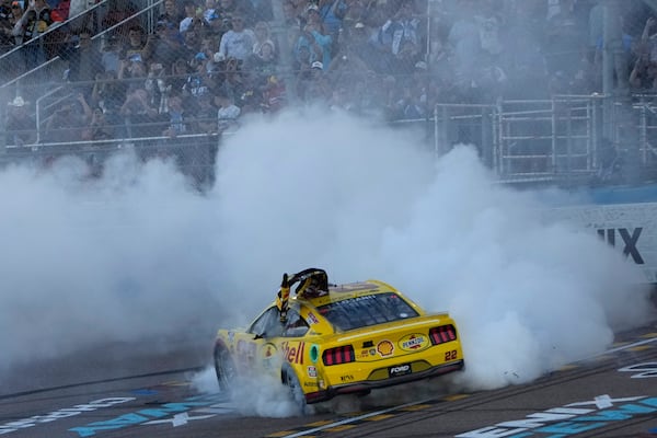 Joey Logano does a burnout after winning a NASCAR Cup Series Championship auto race for the championship at Phoenix Raceway, Sunday, Nov. 10, 2024, in Avondale, Ariz. (AP Photo/John Locher)