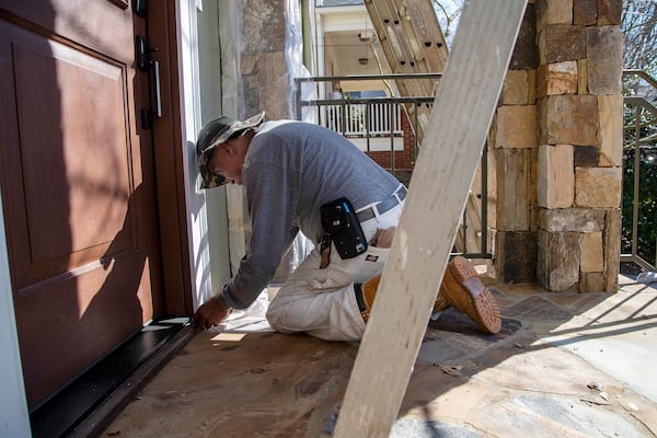 360 Painting of North Georgia painter Rafael Bail uses painters plastic and painters tape to prepare a house for painting in Atlanta’s Virginia Highlands community, Tuesday, March 9, 2021. (Alyssa Pointer / Alyssa.Pointer@ajc.com)