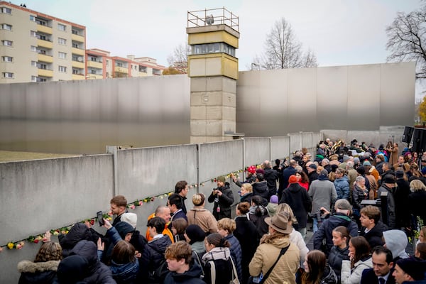 People attend a flower laying ceremony on occasion of the 35th wall anniversary at the grounds of the Berlin Wall Memorial, Berlin, Germany, Saturday, Nov.9, 2024. (AP Photo/Ebrahim Noroozi)