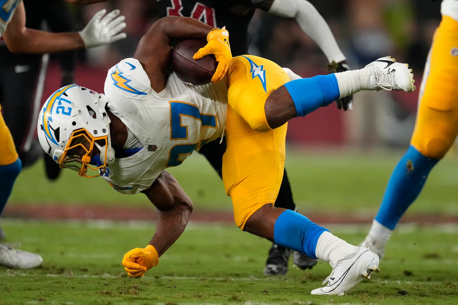 Los Angeles Chargers running back J.K. Dobbins (27) is tackled as he runs up field during the first half of an NFL football game against the Arizona Cardinals, Monday, Oct. 21, 2024, in Glendale Ariz. (AP Photo/Matt York)