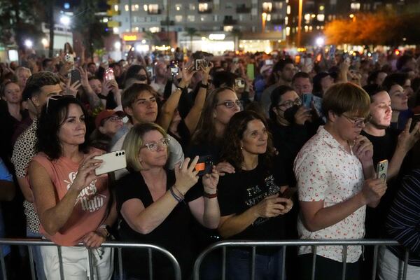 People watch as Sen. Bernie Sanders, I-Vt., and Rep. Alexandria Ocasio-Cortez, D-N.Y., speak outside of Arizona State University to the overflow crowd that did not get inside the arena, during a "Fighting Oligarchy" tour event Thursday, March 20, 2025, in Tempe, Ariz. (AP Photo/Ross D. Franklin)