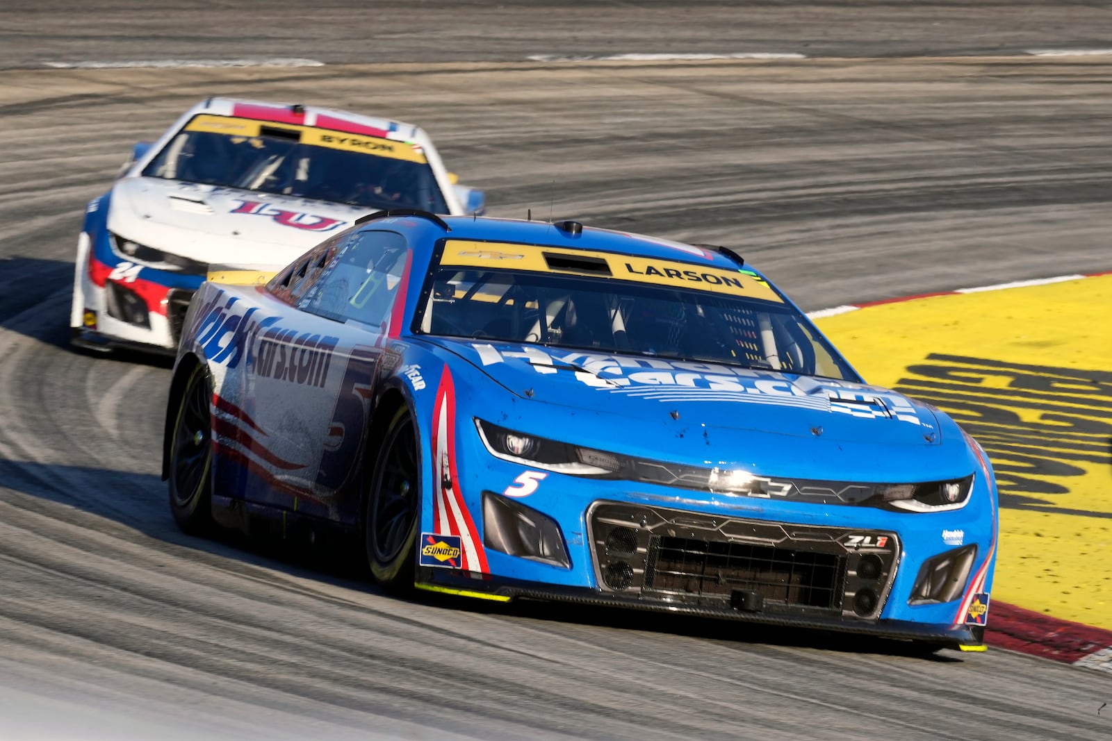 Kyle Larson (5) leads William Byron (24) out of Turn 4 during a NASCAR Cup Series auto race at Martinsville Speedway in Martinsville, Va., Sunday, Nov. 3, 2024. (AP Photo/Chuck Burton)