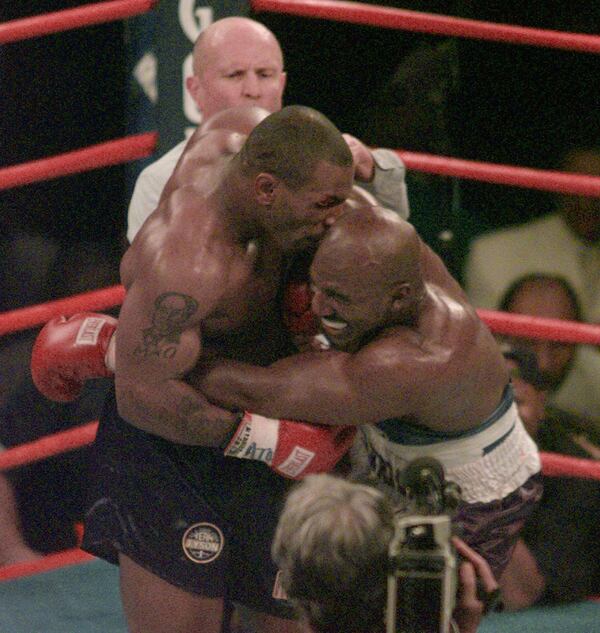 Mike Tyson goes in for a taste of Evander Holyfield's ear during their second fight in 1997. (AP Photo/Jack Smith)