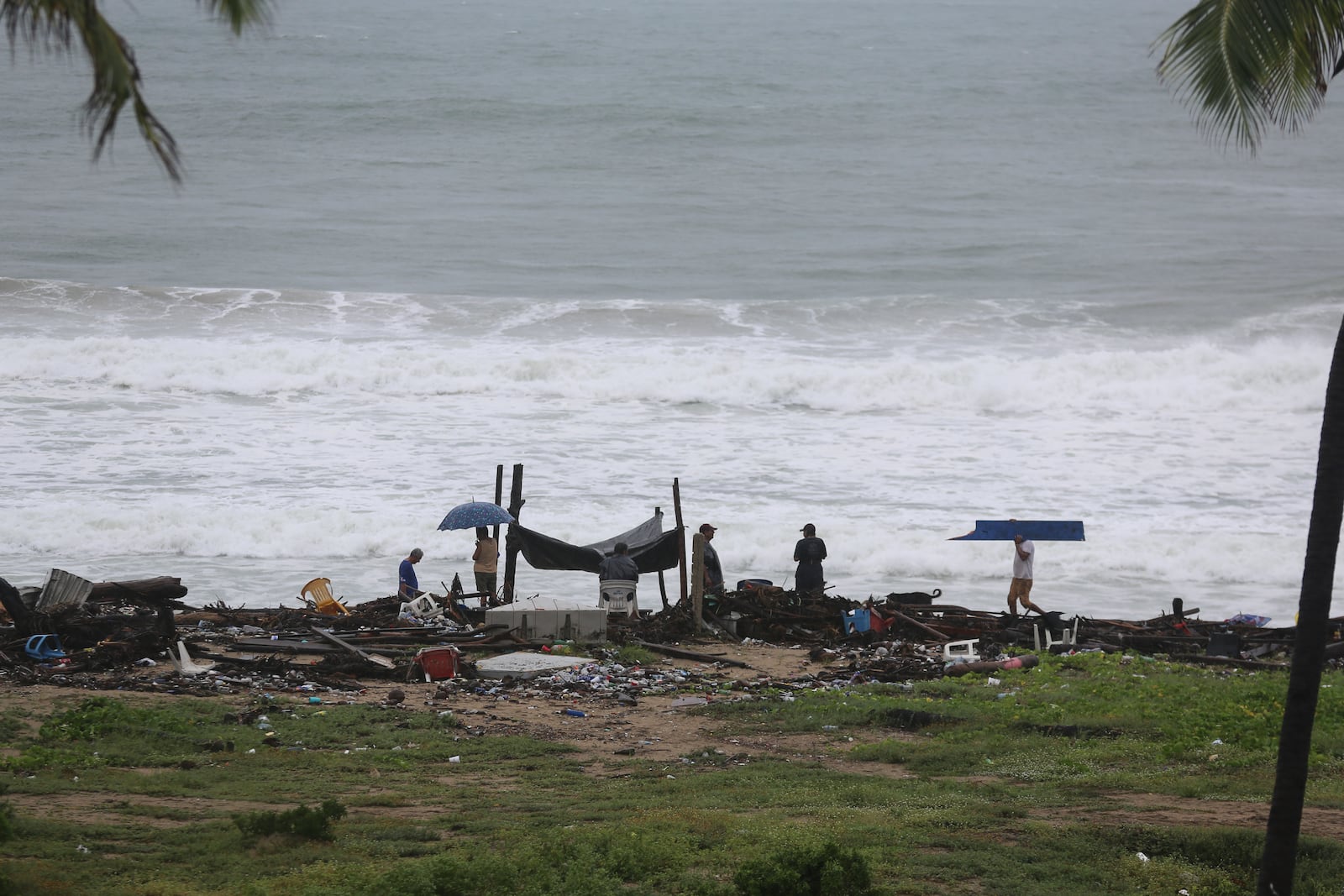 Residents cull for personal items in the debris scattered along the shore in the aftermath of Hurricane John, in Acapulco, Mexico, Friday, Sept. 27, 2024. (AP Photo/Bernardino Hernandez)