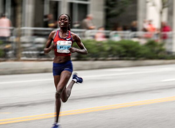 A front runner in the women’s elite foot race pushes down the final stretch of 10th Street NE during the AJC Peachtree Road Race in Atlanta, Thursday, July 4, 2019.