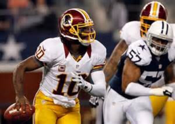 Washington quarterback Robert Griffin III threw for four touchdowns for the second consecutive week and helped hold off a late rally by Dallas. (TIM SHARP/ASSOCIATED PRESS)