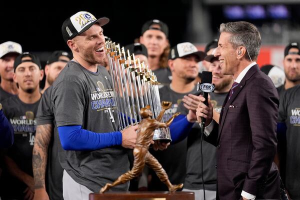 Los Angeles Dodgers' Freddie Freeman celebrates with the trophy after their win against the New York Yankees in Game 5 to win the baseball World Series, Thursday, Oct. 31, 2024, in New York. (AP Photo/Ashley Landis)