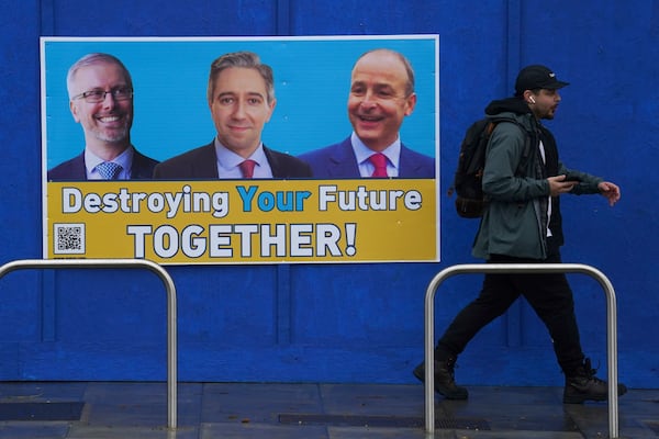 A man walks past a campaign poster in Dublin, Friday Nov. 29, 2024, as voters go to the polls in the 2024 General Election in Ireland. (Brian Lawless/PA via AP)