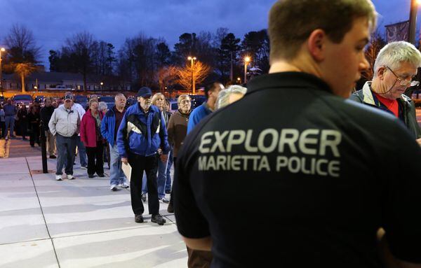 Brent Gunkle, with the Marietta Police Explorers, watches the door as hundreds of people arrive for an active shooter seminar put on by the police department Wednesday evening at Marietta High School. Police say 800 people registered for the seminar and at least 200 more tried to register. Ben Gray / bgray@ajc.com