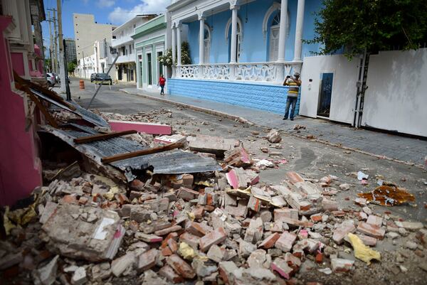 A resident, wearing a protective face mask as a precaution against the spread of the new coronavirus, makes photos of damage caused by a 5.4-magnitude earthquake, in Ponce, Puerto Rico, Saturday, May 2, 2020. The quake hit near southern Puerto Rico, jolting many from their beds on an island where some people still remain in shelters from previous quakes earlier this year. (AP Photo/Carlos Giusti)