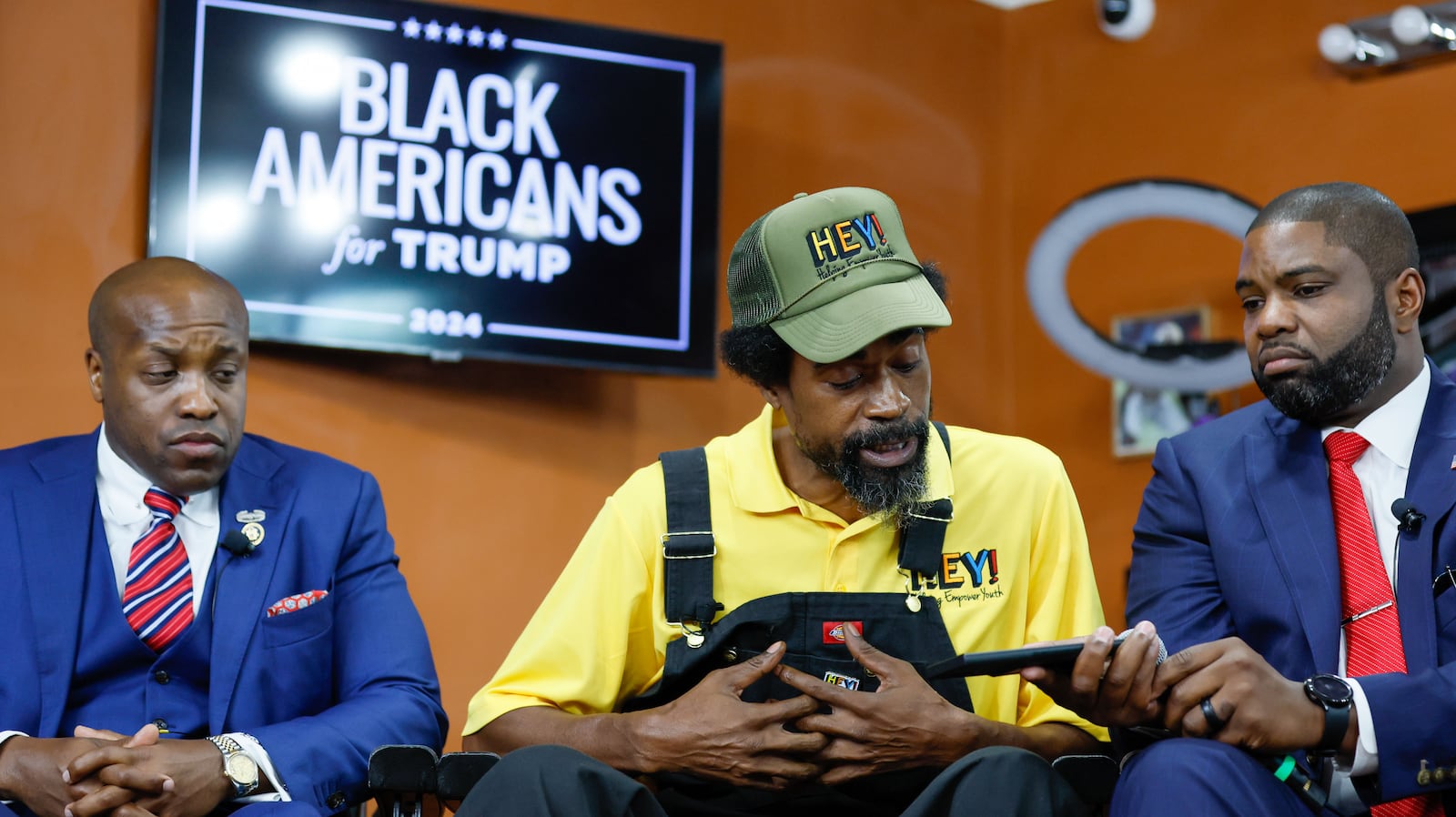 Marc KD Boyd, Founder of HEY (Helping Empower Youth), asks President Donald Trump a question as Congressman Byron Donalds holds a phone during a black leaders’ roundtable at Rocky’s Barbershop in Buckhead on Wednesday, June 26, 2024.
(Miguel Martinez / AJC)