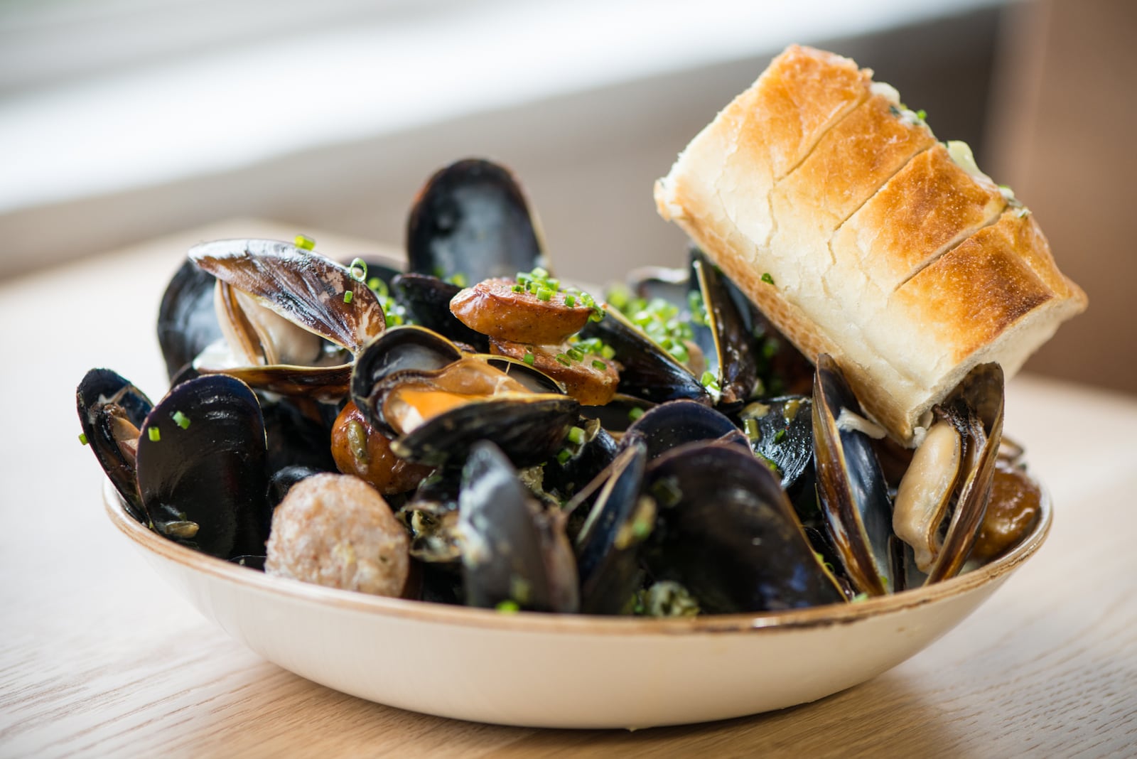 Bangs Island Mussels with andouille, caper butter, and crusty bread at Scout in Oakhurst. / Photo credit- Mia Yakel.