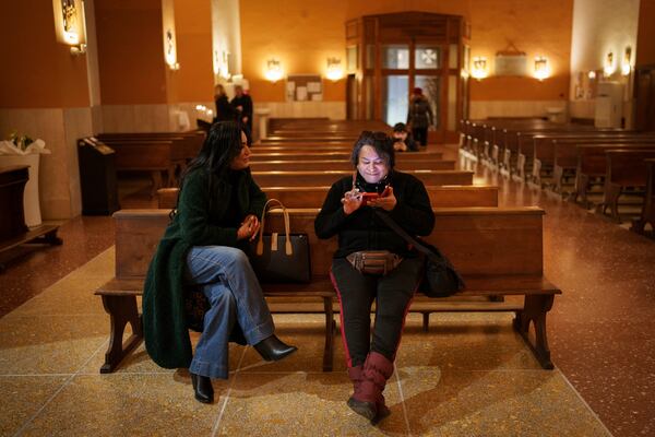 Transgenders Carla Segovia, left, and Minerva sit inside Beata Vergine Immacolata parish church in Torvaianica, Italy, Thursday, Feb. 27, 2025. (AP Photo/Bernat Armangue)