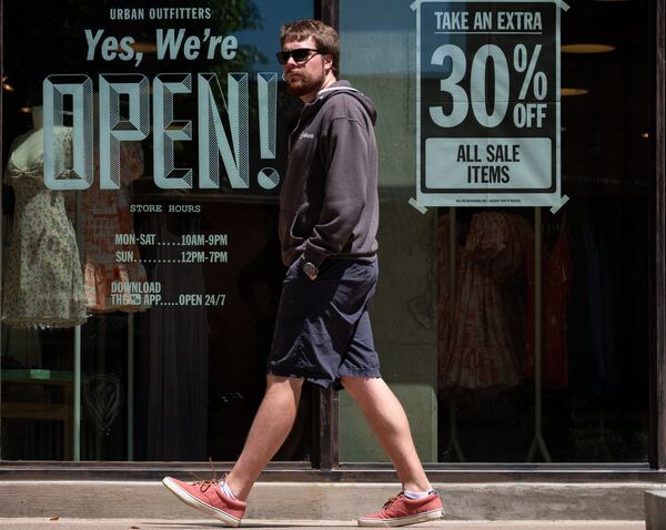 Adam Kryschuk strolls through the Avalon outdoor shopping area in Alpharetta on Friday morning May 1, 2020. Kryschuk, who lives nearby, came with Amy Heigl to walk the dog and see what stores were opening up. Ben@BenGray.com for the Atlanta Journal-Constitution