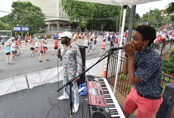 Members of We Were Here perform as runners make their way down Peachtree Road during the 50th AJC Peachtree Road Race on Thursday, July 4, 2019. (Hyosub Shin / Hyosub.Shin@ajc.com)