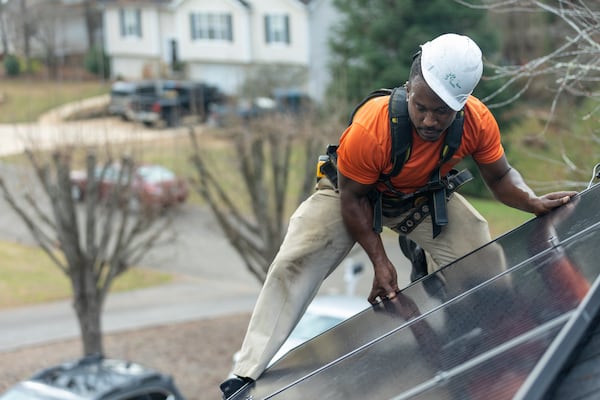 Mike Harris, an installer for Creative Solar USA, installs solar panels on a home in Ball Ground, Georgia on December 17th, 2021. (Nathan Posner for The Atlanta Journal-Constitution)