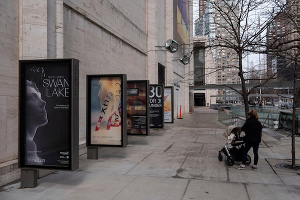 A person walks past a poster for New York City Ballet's "Swan Lake" outside Lincoln Center, Tuesday, Feb. 25, 2025, in New York. (AP Photo/Julia Demaree Nikhinson)