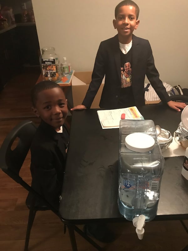 Ja’Den St. Hilaire (left), 7, and his brother Anthony Roberson, 10 are the owners of Brown Boys Lemonade. Here, they give a lemonade-making demonstration in their Doraville home. (Photo by Ligaya Figueras)