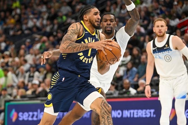 Indiana Pacers forward Obi Toppin, left, drives past Minnesota Timberwolves center Naz Reid during the first half of an NBA basketball game Monday, March 17, 2025, in Minneapolis. (AP Photo/Craig Lassig)