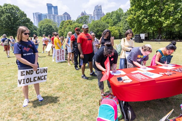 Participants sign in before a rally organized by Georgia Moms Demand Action in Piedmont Park on Saturday, May 13, 2023. The rally was part of a national series of protests the day before Mother’s Day to highlight the mounting toll of gun violence. (Steve Schaefer/steve.schaefer@ajc.com)